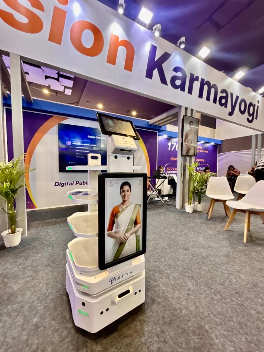 A Thrifty AI service robot with an AI ambassador in a saree on its screen at the Mission Karmayogi pavilion